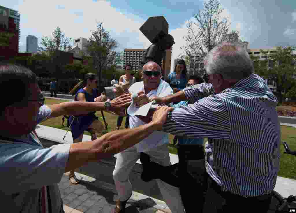 Miembros de la Vigilia Mambisa pelean con un hombre a su llegada para asistir a la intervención de de la bloguera y disidente cubana Yoani Sánchez hoy, lunes 1 de abril de 2013, en la emblemática Torre de la Libertad de Miami, Florida, todo un icono del é