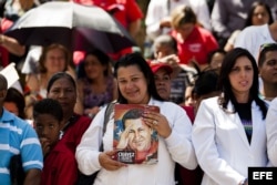 Una enfermera sostiene una imagen del fallecido líder Hugo Chávez hoy, lunes 10 de marzo de 2014, durante el acto de graduación de médicos venezolanos.