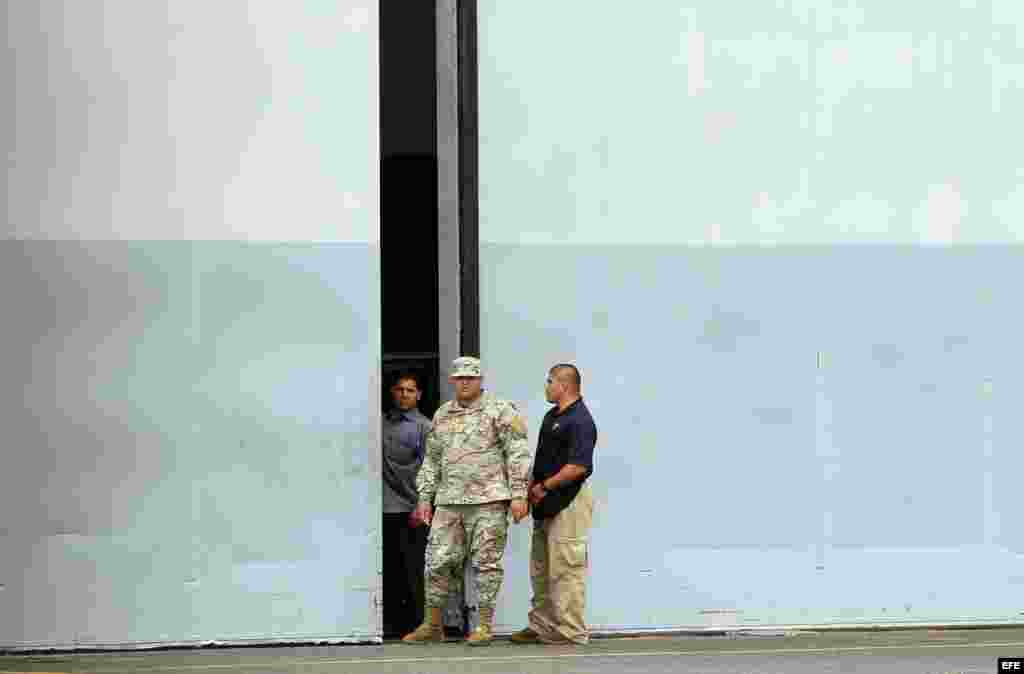 Un grupo de policías custodia la entrada del hangar donde se encuentran depositados los armamentos encontrados en el buque norcoreano Chong Chon Gang hoy, martes 13 de agosto de 2013, en la antigua base aérea de Howard, en el pacifico panameño. Una misión