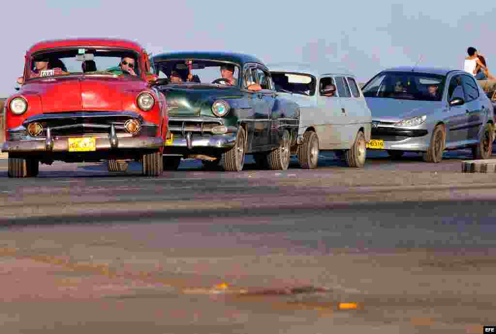 Varios autos circulan por el malecón habanero. 