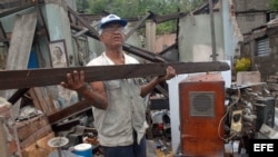  Un hombre rescata algunas pertenencias de su hogar, destruido por el paso del huracán "Sandy", en la ciudad de Santiago de Cuba. La urbe, en el este de la isla, fue una de las zonas más castigadas por el paso del huracán, con derrumbes de viviendas