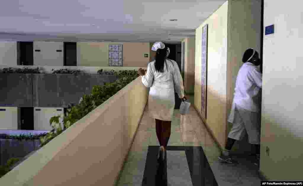 Con una máscara contra la propagación del nuevo coronavirus, la enfermera Yenis Mercedes recorre las habitaciones del hotel Meliá Habana para controlar la temperatura de los turistas, en La Habana, Cuba, el jueves 11 de febrero de 2021. (AP Foto/Ramón Espinosa)