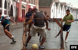 Jóvenes cubanos juegan fútbol soccer.