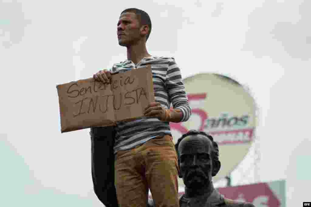 Un hombre sostiene un cartel con el mensaje "sentencia injusta" en referencia a la condena dictada al dirigente opositor Leopoldo López.