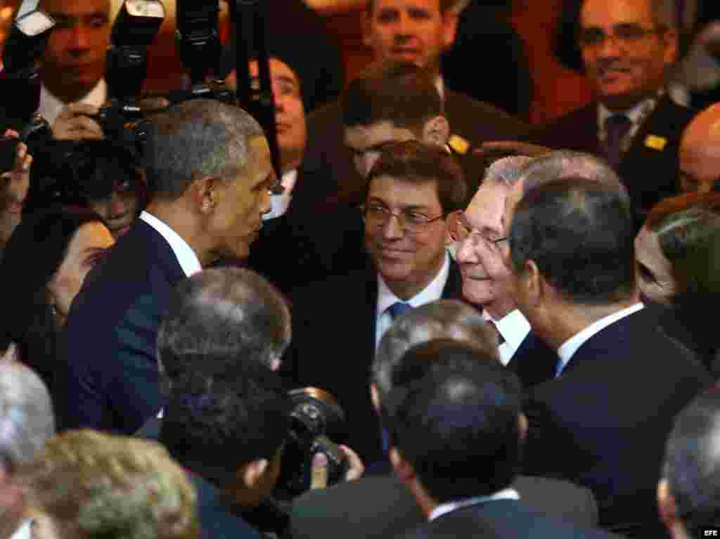 Barack Obama saluda a Raúl Castro. Al fondo, el canciller cubano Bruno Rodríguez Parrilla.